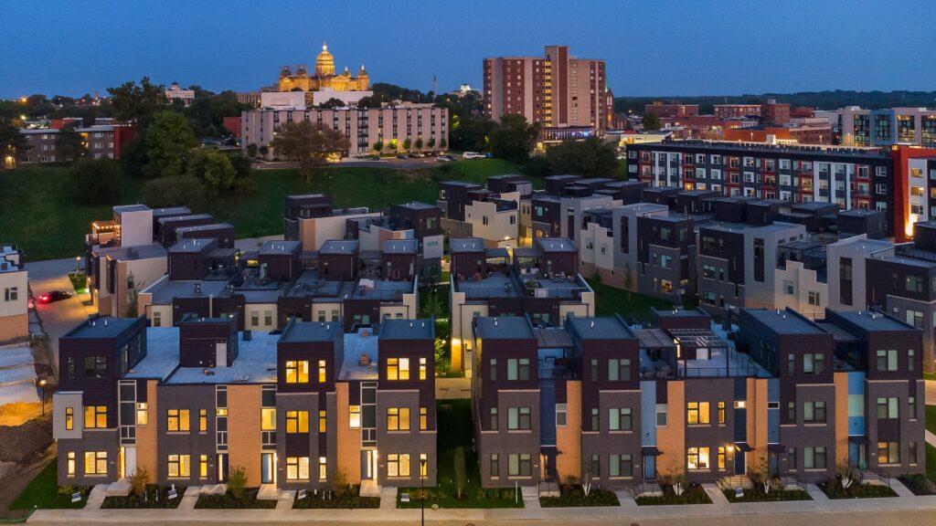 Aerial view of a dense modern townhome community at dusk with a historic domed building visible in the background.