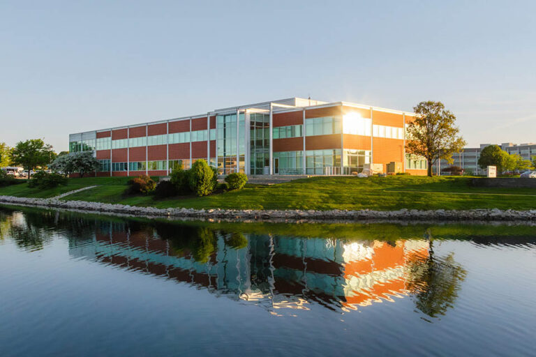 Hubbell office building at sunset with its reflection visible in a calm pond.