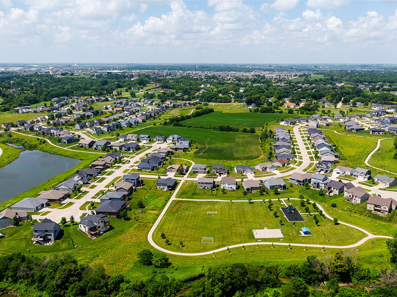 Aerial view of a large neighborhood featuring many homes and plush green grass