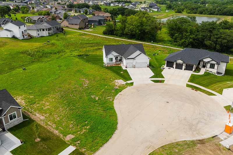 Drone view of homes with an available lot in between the homes
