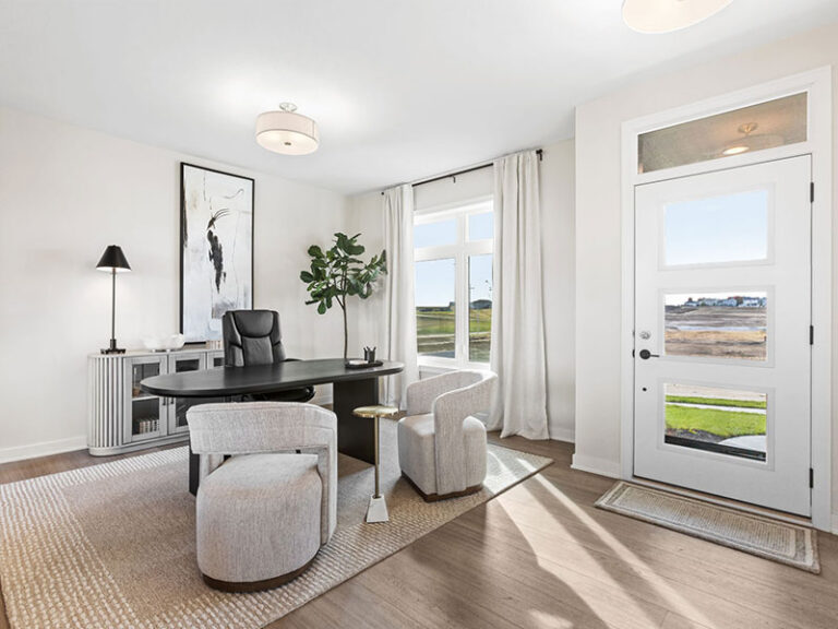 Bright home office with a desk, chairs, large window, and front door.