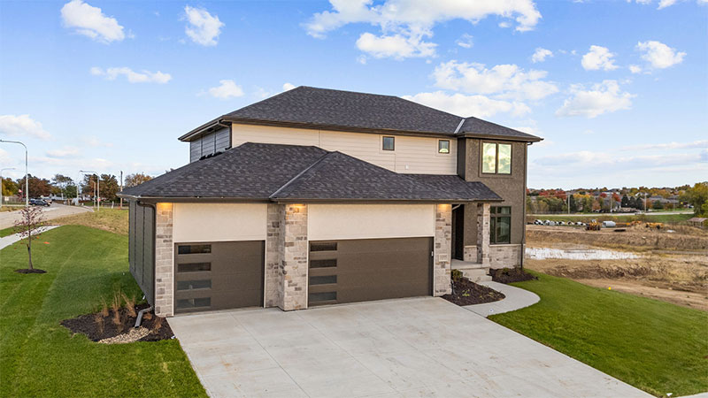 Modern two‑story home with stone accents and a three‑car garage.