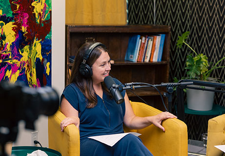 Women sitting in chair with podcast microphone