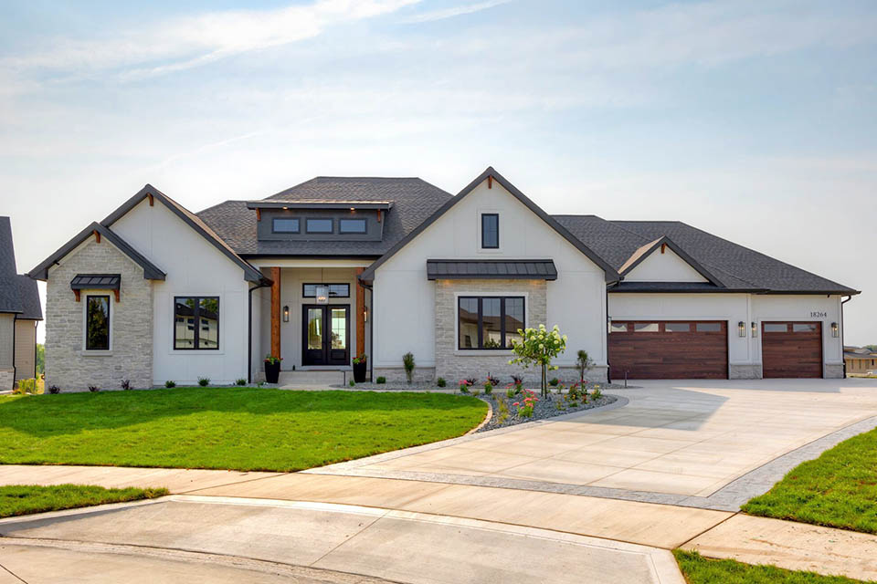 Modern single‑story home with white exterior, dark trim, and a landscaped front yard.