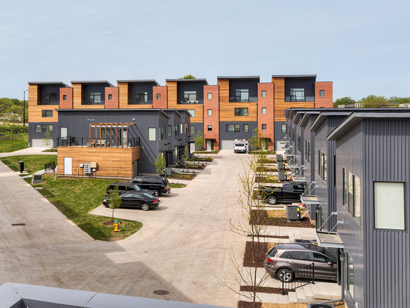 Aerial view of a modern townhouse community with shared driveways and parked cars.