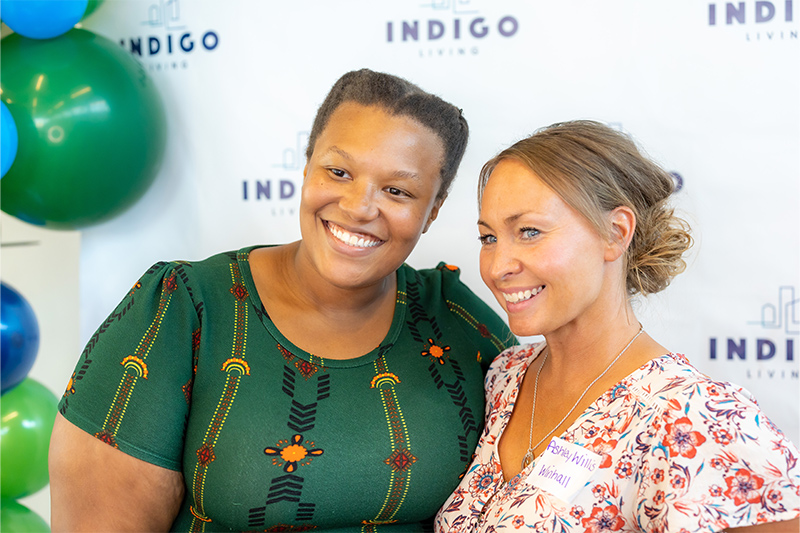 Two people standing together at a celebration smiling together