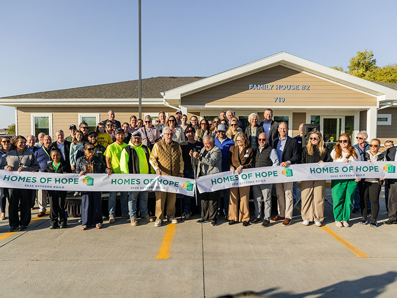 People standing at a ribbon cutting ceremony for Building Hope