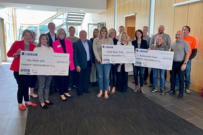 Multiple people holding large checks for charity