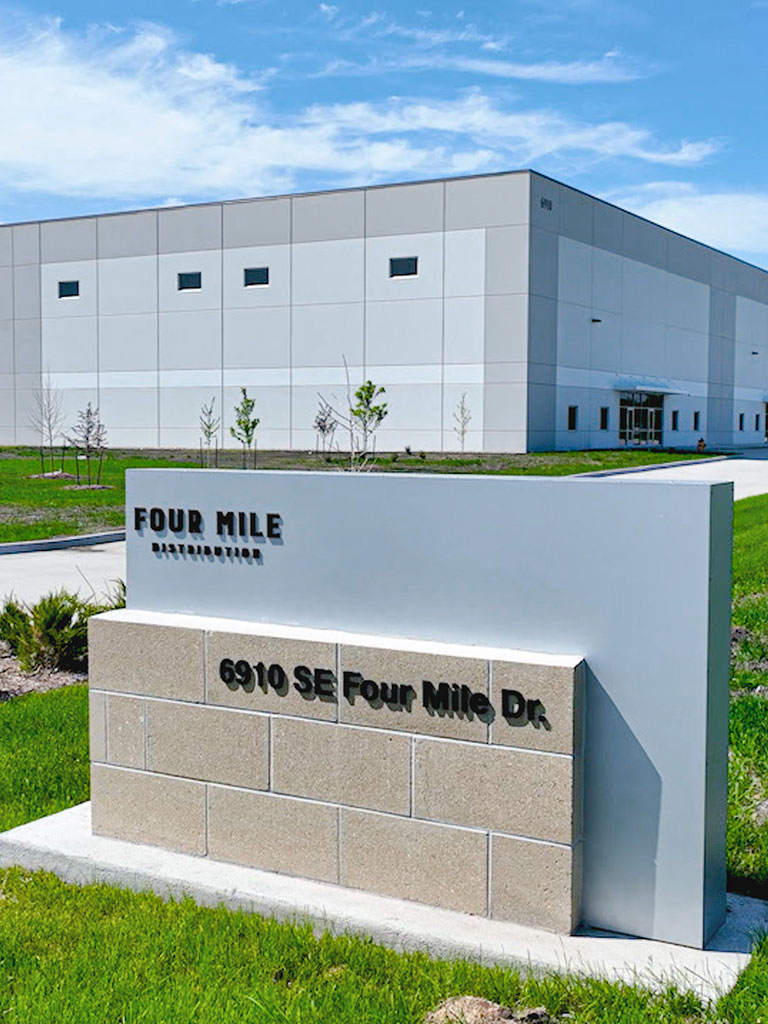 Front view of the Hubbell Four Mile Distribution building entrance with a foreground monument sign reading ‘6910 SE Four Mile Dr.