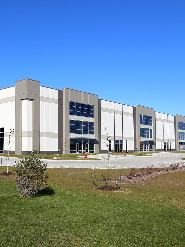 Front view of the Hubbell Grimes Distribution Center showing the modern industrial façade, large windows, and landscaped green space.
