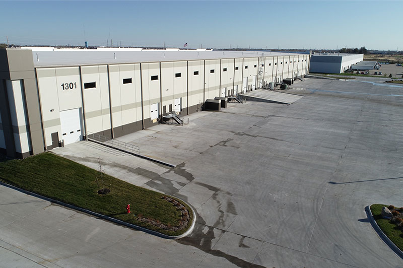 Side angle view of the Hubbell Grimes Distribution Center’s long row of dock doors and expansive paved truck court.