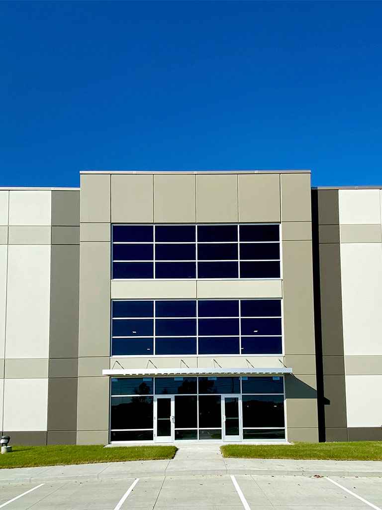 Close‑up of the Hubbell Grimes Distribution Center main entrance with large glass windows and clean architectural lines.