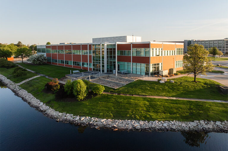 Aerial view of an upscale brick office building featuring many windows and overlooking a body of water