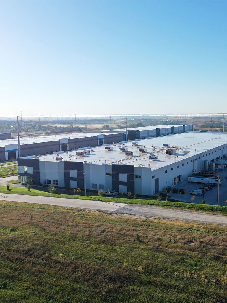 Aerial view of the Hubbell Infinity Industrial Center Building featuring a large modern warehouse with rooftop equipment and surrounding access roads.