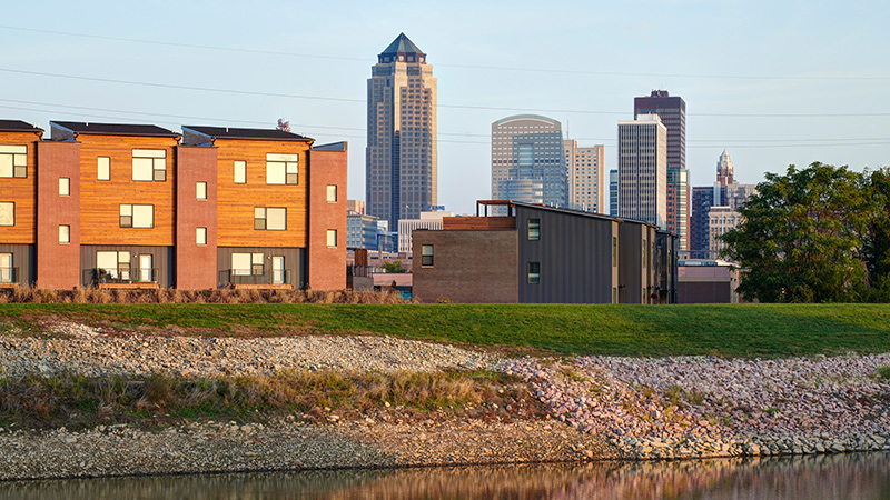 Wood and brick apartments against the Des Moines skyline