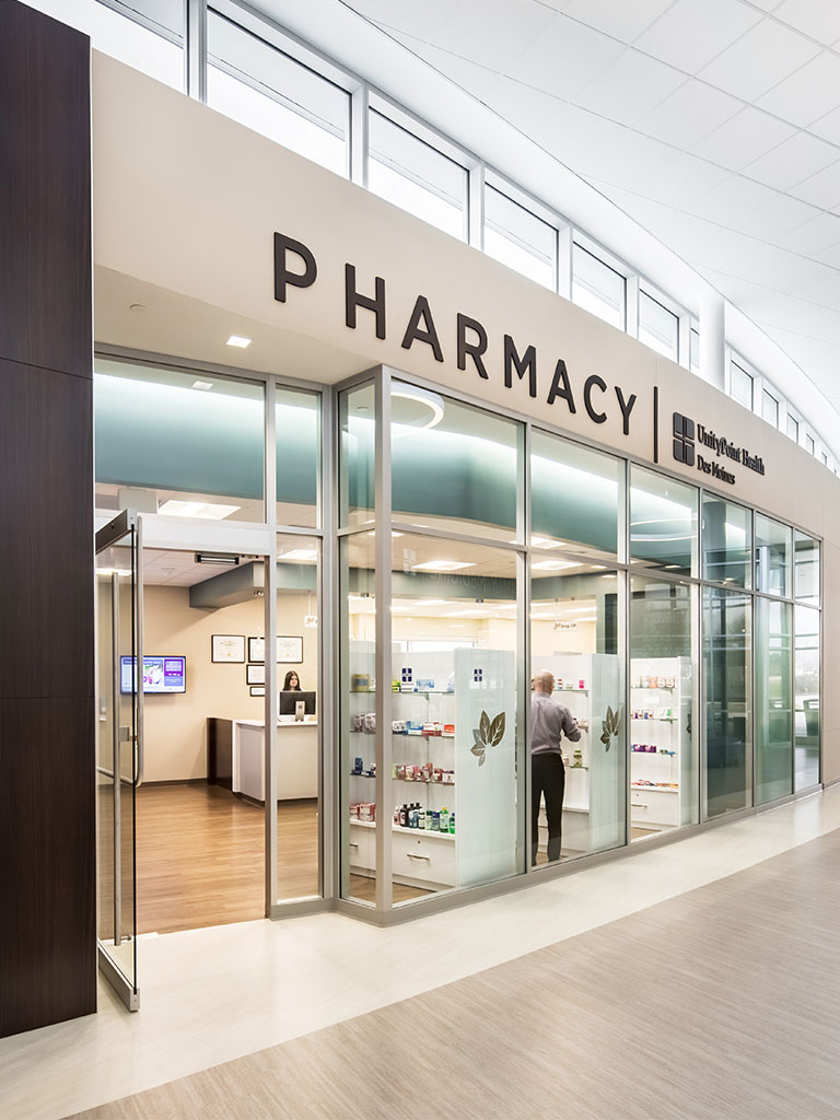 Close view of the pharmacy storefront inside the Hubbell North Ankeny Medical Park with large glass panels and visible shelving.