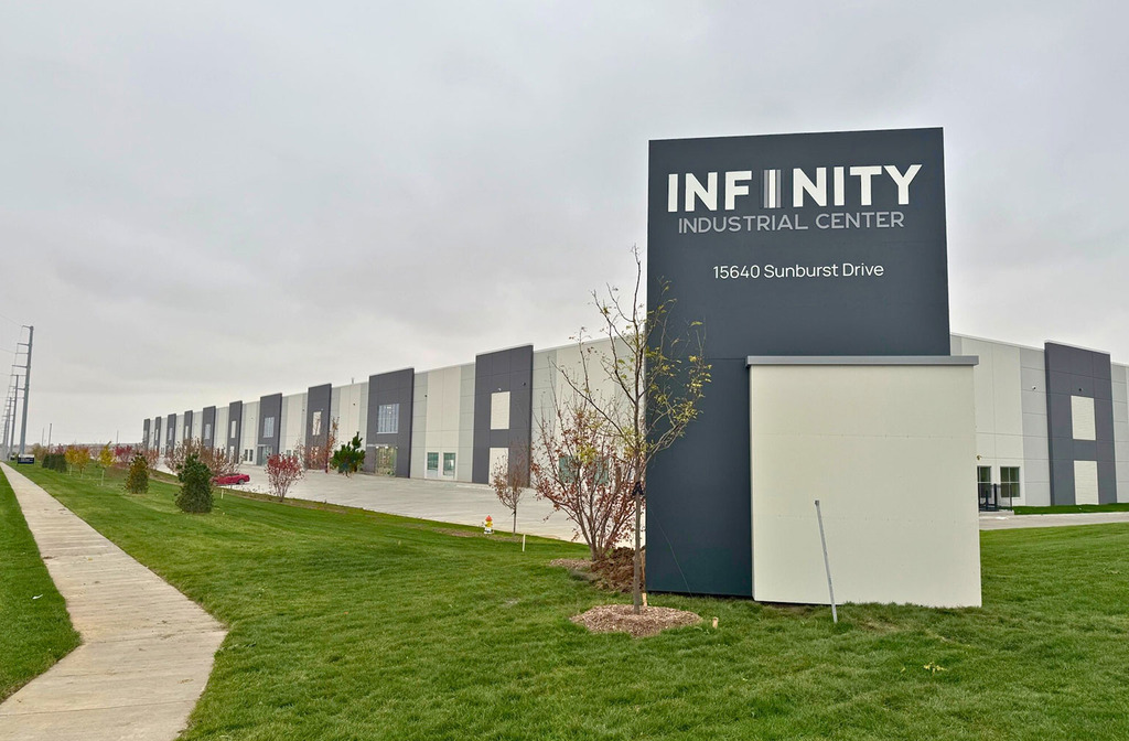 View of the Hubbell Infinity Industrial Center Building’s long façade with landscaped lawn and large windows along the entry façade.